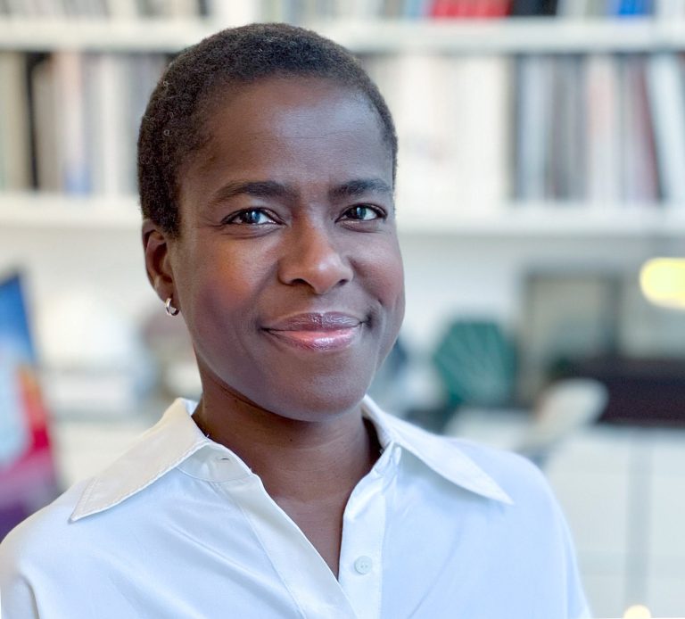 Lara Akeju headshot, standing in workplace